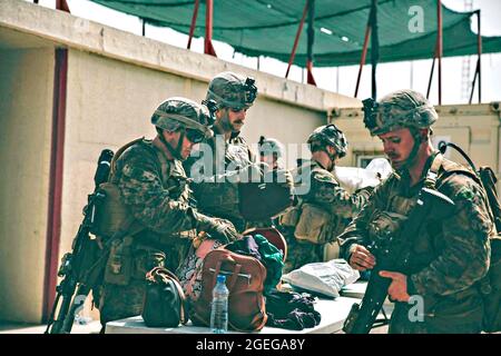 Kaboul, Afghanistan. 18 août 2021. Des Marines américains affectés à la 24e unité expéditionnaire maritime, vérifient les bagages lors de l'évacuation des civils à l'aéroport international Hamid Karzaï dans le cadre de l'opération alliés refuge le 18 août 2021 à Kaboul, en Afghanistan. Credit: Planetpix/Alamy Live News Banque D'Images