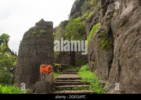 Porte d'entrée principale avec l'idole Hanuman sculptée en roche au fort Hatgad, Nashik, Maharashtra, Inde. Banque D'Images