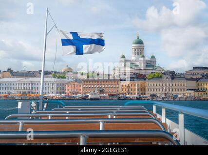 Vue sur la ville d'Helsinki en bateau avec drapeau finlandais et cathédrale d'Helsinki - Helsinki, Finlande Banque D'Images