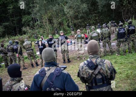 Des gardes-frontières sont vus pour protéger les réfugiés afghans à la frontière polonaise et biélorusse. Le nombre croissant de personnes qui tentent de traverser la Pologne transforme les migrations en une question politique intérieure en Pologne. Dans un village frontalier d'Usnarz Gorny, il y a un écart entre les gardes-frontières biélorusses et polonaises avec plus de 30 000 réfugiés afghans bloqués au milieu. Les réfugiés y sont restés depuis près de deux semaines car ils ne sont pas autorisés à entrer en Pologne ou à rentrer au Bélarus. La Pologne a déployé des centaines de troupes le long de sa frontière avec le Bélarus pour arrêter l'arrivée de migrants cherchant à entrer dans le décompte Banque D'Images