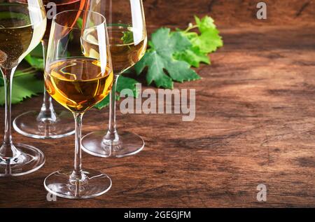 Ensemble vin blanc. Dégustation de vins, les variétés de vins blancs les plus populaires dans des verres à vin sur une table en bois vintage dans un style rustique, concentration sélective Banque D'Images