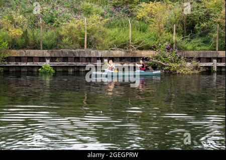 Deux filles utilisant un canot louent un bateau sur la rivière Yare près de Norwich Banque D'Images