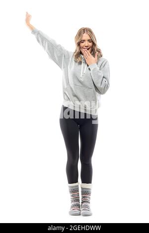 Mignon paresseux jeune jolie femme se réveillant bras étirants et bâillonne le matin. Portrait du corps entier isolé sur fond blanc Banque D'Images