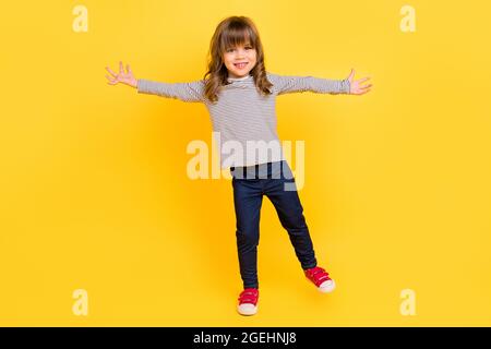 Photo du corps complet de funky petit blond cheveux fille main main porter chemise jeans baskets isolé sur le dos jaune Banque D'Images