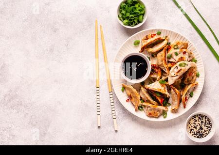 Boulettes frites servies avec des oignons verts, des graines de sésame et des piments, vue de dessus Banque D'Images