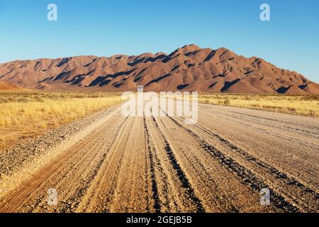 Route de gravier et beau paysage avec ciel de coucher de soleil en Namibie, Afrique Banque D'Images