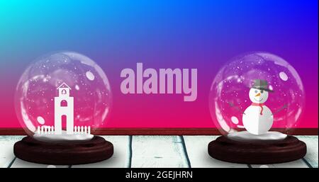 Image de deux globes de neige avec bonhomme de neige et tour d'église sur fond bleu dégradé à rose Banque D'Images