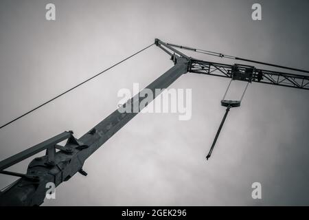 Prise de vue en échelle de gris d'une grue de construction contre un ciel gris Banque D'Images