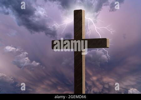 Image dramatique montrant une croix d'église religieuse encadrée contre un ciel de moody qui commence à s'ouvrir et à percer la lumière à travers derrière la croix, showin Banque D'Images