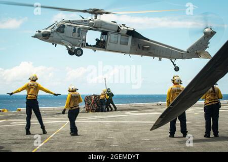 OCÉAN PACIFIQUE (août 14, 2021) les Marines des États-Unis, avec la 11e unité expéditionnaire maritime (UMM) et les marins affectés au quai de transport amphibie USS Portland (LPD 27), se préparent à transporter des cargaisons sous un Hawk de mer MH-60S affecté au Escadron de combat en mer par hélicoptère 4 lors d'un réapprovisionnement vertical en mer, le 14 août. Les Marines et les marins du 11e MEU et du groupe de prêt amphibie d'Essex (ARG) sont en cours d'exécution des opérations de routine dans la 3e flotte américaine. (É.-U. Photo du corps marin par Sgt. Alexis Flores) Banque D'Images