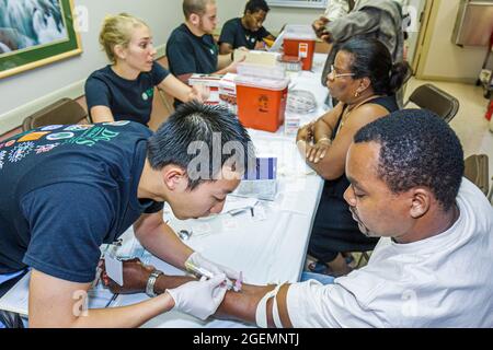 Miami Florida,Liberty City,Jessie Trice Community Health Centre examen de soins gratuits, travailleur bénévole Noir asiatique homme, échantillon de test sanguin lat Banque D'Images
