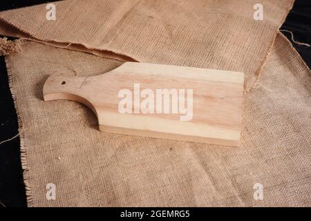 planche à découper en bois avec fond de texture toile de jute. conception de matériau avec un concept minimaliste pour un fond de texte ou de décoration Banque D'Images