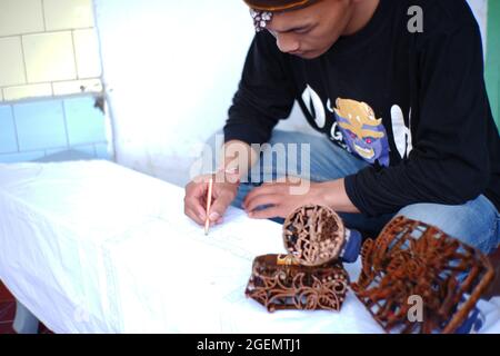 Pasuruan, Indonésie. Juin 2021. Gros plan d'un homme faisant batik typique de la tribu de Bromo Tengger. Jeunes artistes qui préservent l'ethnicité et la culture dans Banque D'Images