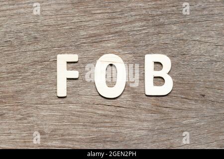 Lettre alphabétique du mot FOB (abréviation de Free on Board) sur fond de bois Banque D'Images