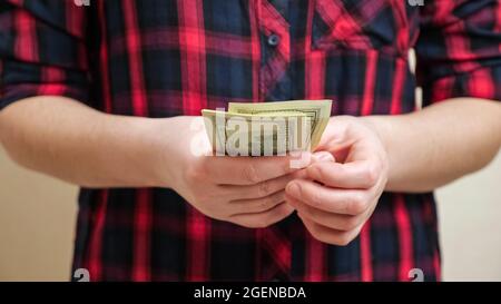 La femme compte les billets en dollars qui se tiennent entre les mains de près Banque D'Images