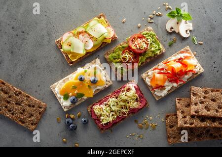 Vue de dessus de délicieux toasts de pain croustillant avec fromage à la crème et fruits et légumes frais Banque D'Images