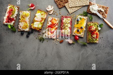 Vue de dessus des toasts de pain croustillant assortis avec fruits et légumes frais servis sur la table Banque D'Images