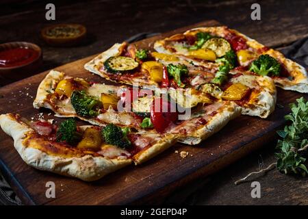 Pizza végétarienne appétissante avec divers légumes placés sur une table en bois Banque D'Images