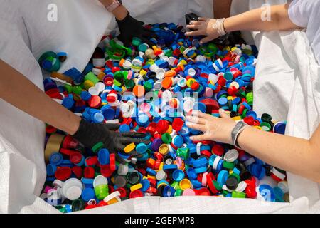 Des milliers de bouchons en plastique colorés sont triés pour recyclage. Banque D'Images