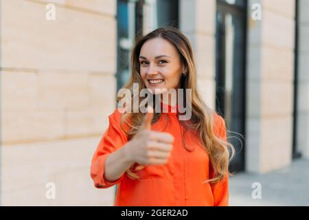 Femme de la trentaine souriant et montrant les pouces vers le haut Banque D'Images