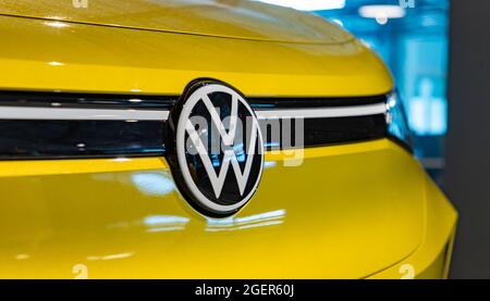 Une photo du logo Volkswagen à l'avant d'une voiture jaune vif. Banque D'Images