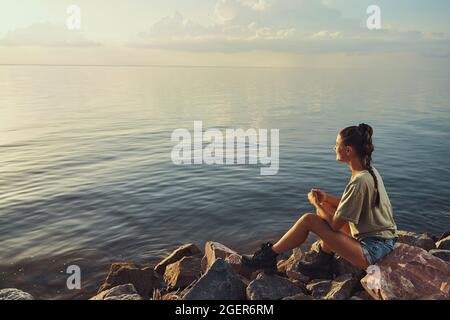 Jeune femme ayant un repos paisible sur le lac Banque D'Images