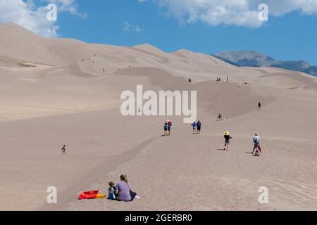 Colorado, San Luis Valley, parc national de Great Sand Dunes. Grandes dunes de sable mesurant jusqu'à 750 mètres. Touristes appréciant les dunes. Banque D'Images