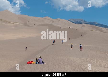 Colorado, San Luis Valley, parc national de Great Sand Dunes. Grandes dunes de sable mesurant jusqu'à 750 mètres. Touristes appréciant les dunes. Banque D'Images