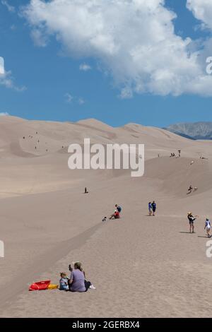 Colorado, San Luis Valley, parc national de Great Sand Dunes. Grandes dunes de sable mesurant jusqu'à 750 mètres. Touristes appréciant les dunes. Banque D'Images