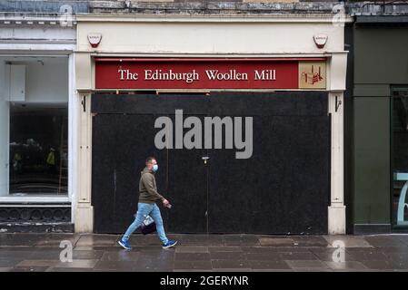 L'homme marche à bord d'une branche à bord du Woolen Mill d'Édimbourg, Princes Street, Édimbourg, Écosse, Royaume-Uni. Banque D'Images