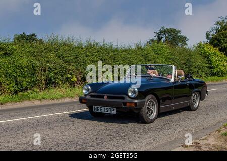 1976 70s noir MG Midget 1491 cc essence cabrio, en route vers Capesthorne Hall Classic July car show, Cheshire, Royaume-Uni Banque D'Images