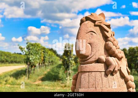 Wiesloch, Allemagne - août 2021: Drôle de sculpture de Dieu du vin appelé 'Peedy Bacchus' avec vignoble flou en arrière-plan Banque D'Images