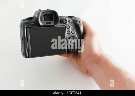 20 août 2021. Anapa, Russie. Appareil photo sans miroir Canon R5 avec main mâle sur fond blanc Banque D'Images