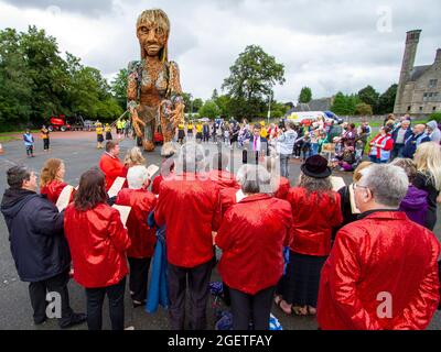 Alloa, Écosse, Royaume-Uni. 21 août 2021. Un chœur se produit. STORM, par compagnie de théâtre, Vision Mechanics, promenades à Alloa. Cette marionnette de 10 mètres de haut raconte l'histoire des océans en crise. STORM est une déesse mythique de la mer, entièrement faite de matériaux recyclés et naturels. Le projet nous encourage tous à célébrer nos mers, à prendre soin de nos côtes et à donner la priorité à l'environnement. Credit: Iain McGuinness / Alamy Live News Banque D'Images