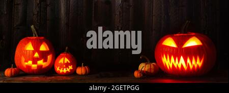 Halloween Jack o lanternes la nuit. Bannière avec espace de copie sur fond en bois sombre. Banque D'Images