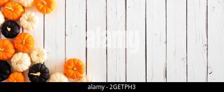 Bordure de coin de citrouille d'automne aux couleurs d'Halloween orange, noir et blanc sur fond de bannière en bois blanc. Copier l'espace. Banque D'Images