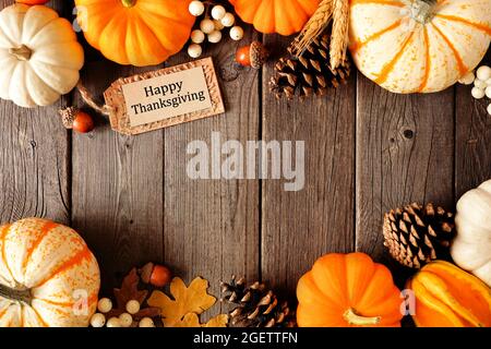 Étiquette cadeau Happy Thanksgiving avec double bordure de citrouilles et décoration d'automne sur fond de bois sombre. Copier l'espace. Banque D'Images