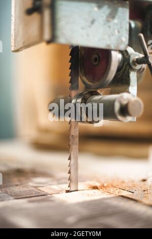 Outils d'atelier. Vue détaillée de la scie sauteuse électrique fixe automatique dans l'atelier de menuiserie. Mobilier artisanal en bois à colombages Banque D'Images