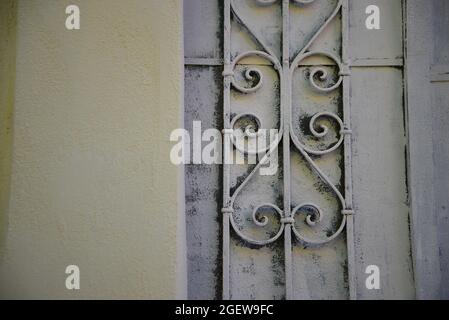 Détail artisanal d'une ancienne porte en fer forgé sur un mur en stuc à Anafiotika, Athènes, Grèce. Banque D'Images