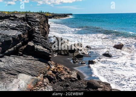 Falaises de mer formées par de récents coulées de Lava sur la plage de sable noir de Kaimu, île d'Hawaï, Hawaï, États-Unis Banque D'Images