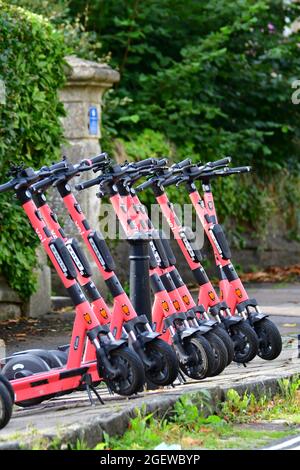 Une rangée de VOI-e-scooters vus prêt pour les gens à louer par téléphone portable qui est attaché au milieu du guidon. classé comme véhicule routier. Banque D'Images