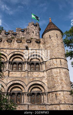 Gand, Flandre, Belgique - 30 juillet 2021 : coin nord-est du mur gris-brun et tours du château médiéval en pierre de Gravensteen sous ciel bleu avec certains Banque D'Images