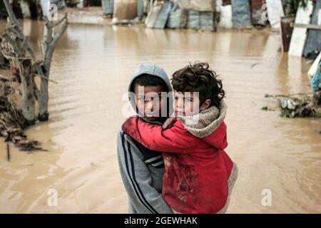 Portrait des enfants palestiniens qui marchent dans l'eau inondée. Gaza. Banque D'Images