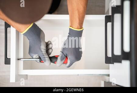 Ébéniste professionnel finition cuisine armoire installation des tiroirs. Vue de dessus gros plan. Thème de l'amélioration de l'habitat. Banque D'Images