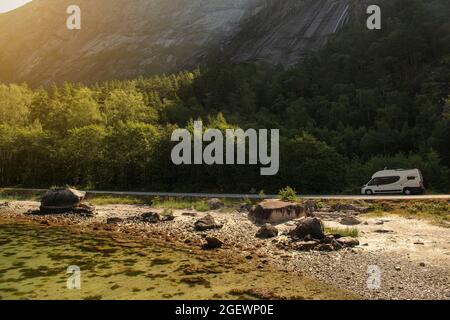 Fourgonnette moderne classe B camping-car sur la route pittoresque du fjord. Bord de mer et falaises abruptes. Paysage norvégien. Banque D'Images