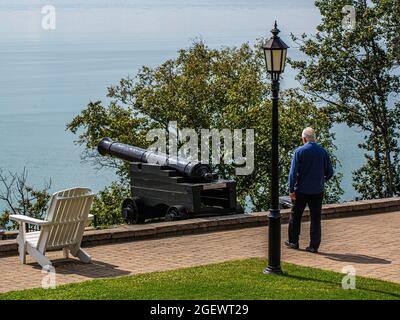 La Malbaie, Canada - juillet 22 2021 : un vieil homme debout près du canon sur le balcon de l'hôtel Fairmont St-Richelieu à la Malbaie Banque D'Images