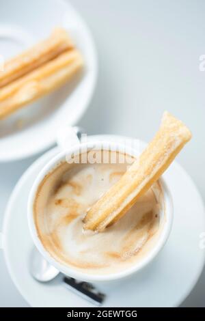 Churros espagnol sur une assiette blanche avec café Banque D'Images