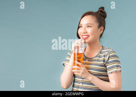 Portrait d'une jolie jeune femme en lunettes de soleil buvant du soda Banque D'Images