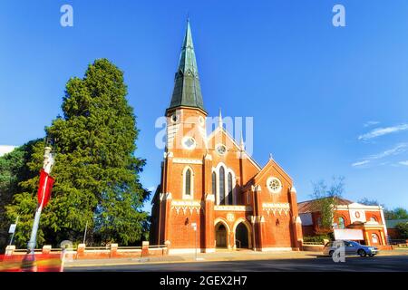 Rue locale dans la ville de Bathurst avec brique rouge historique unissant l'église bâtiment sous ciel bleu. Banque D'Images