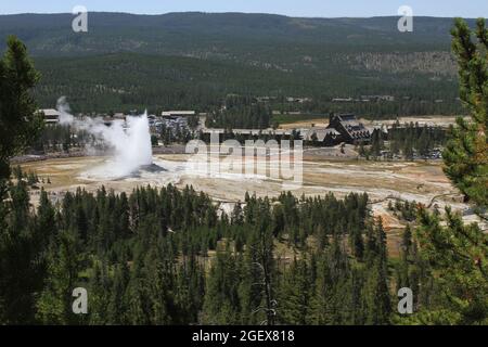 Vue depuis le point d'observation des visiteurs observant le geyser Old Faithful avec l'auberge Old Faithful et le centre des visiteurs Old Faithful en arrière-plan.visiteurs observant le geyser Old Faithful avec l'OFI et l'OFVEC en arrière-plan ; Date : 4 août 2013 Banque D'Images